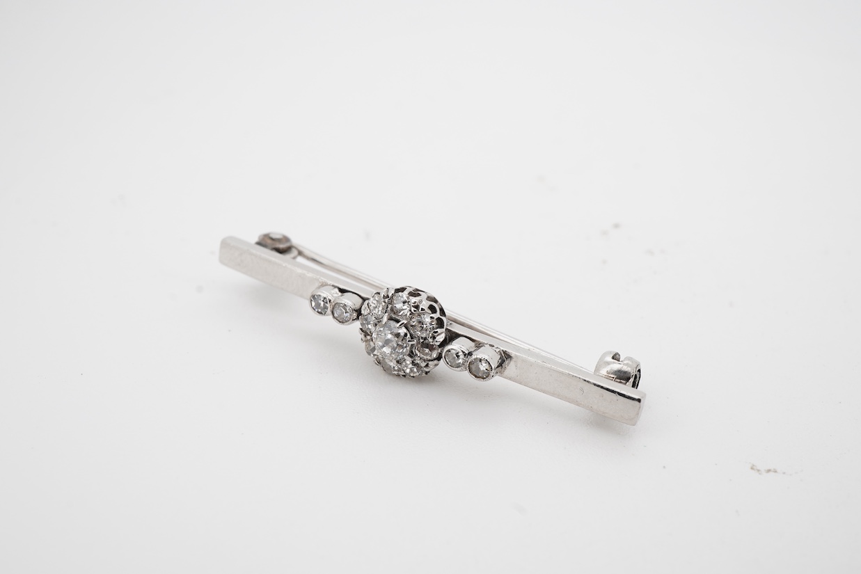 A white metal (stamped 9ct W.G.), and diamond cluster set bar brooch, 38mm.